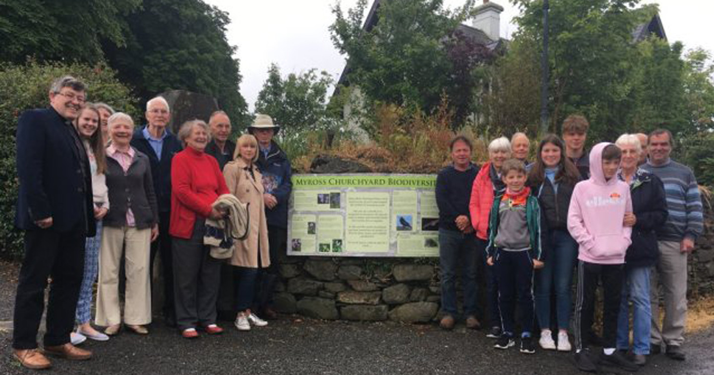Members of the congregation gathered at the information sign: &lsquo;Myross Churchyard Biodiversity&rsquo;.