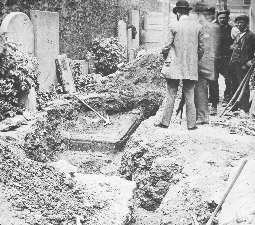A large group of people survey the recent excavation works.