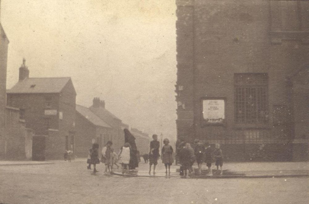 The woman worker with a group of children, probably outside St Mary's Church, Crumlin Road, judging by the size and scale of the building, RCB Library MS 295