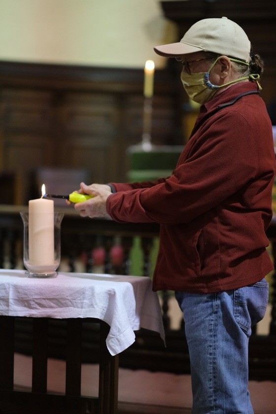 John Sheridan lighting a candle during the service.