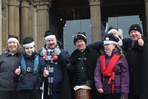 Dean Stephen Forde is joined at the launch of Black Santa 2025 by members of Belfast Lough Sailability.