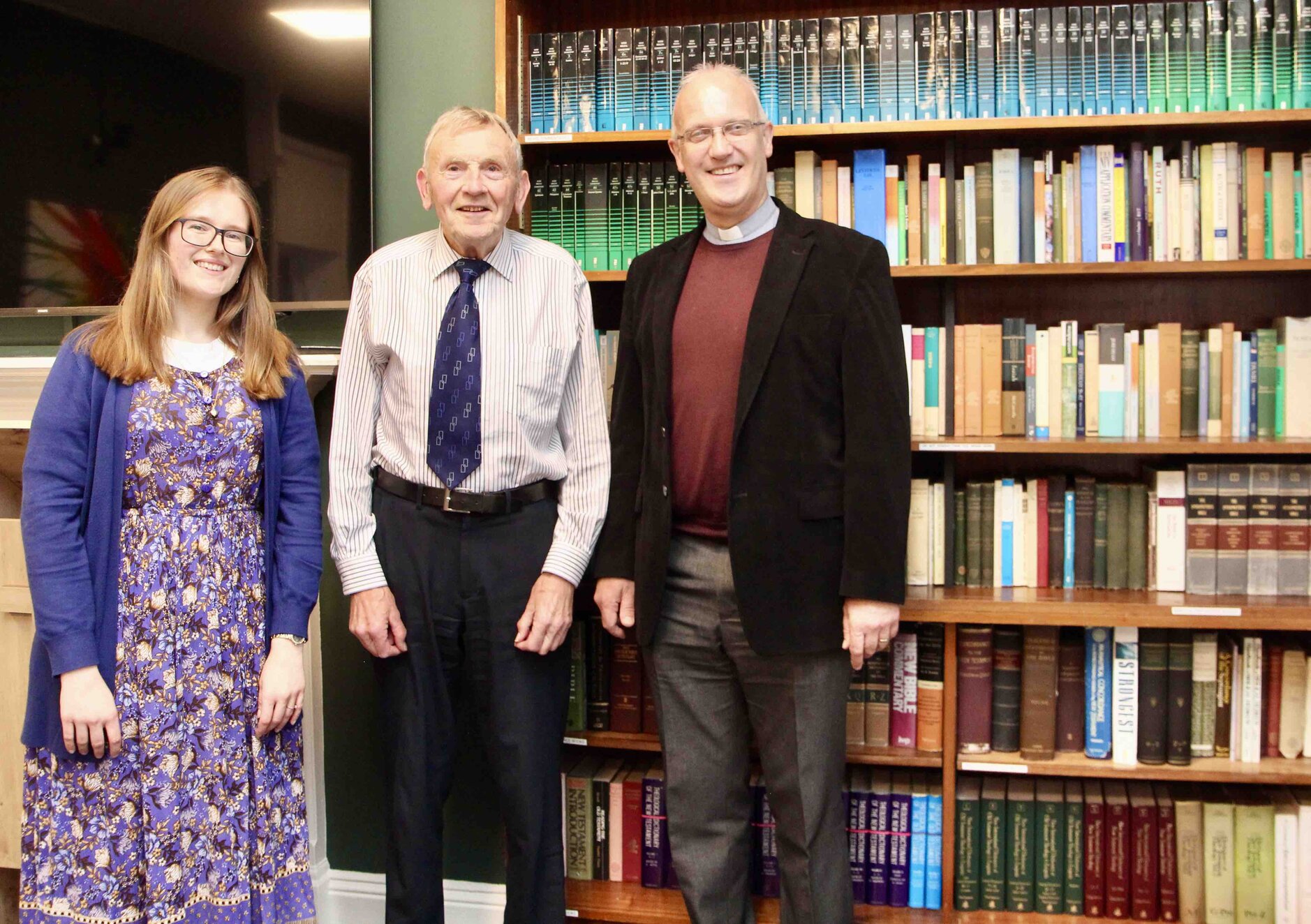 Canon Dr Will Murphy (centre) with senior student Victoria Hawkins and CITI director Canon Dr Maurice Elliott and some of the books donated.