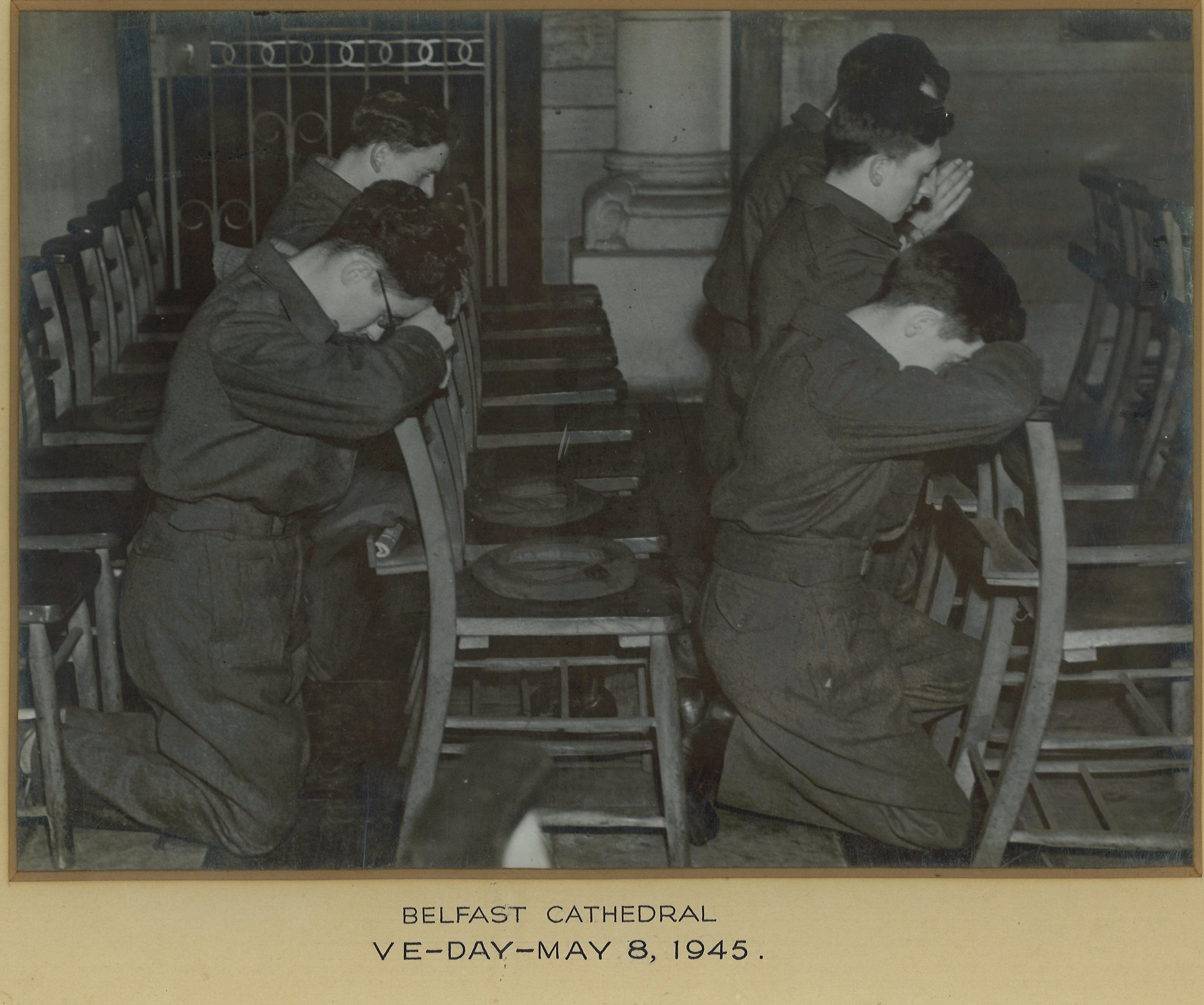 Soldiers kneel for prayer in Belfast Cathedral on VE Day, 8th May 1945.